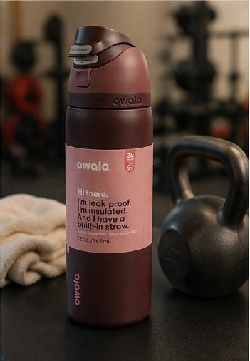 Maroon insulated water bottle beside gym equipment